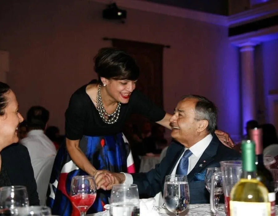 Maria Voutsinas speaking with a guest at a community dinner